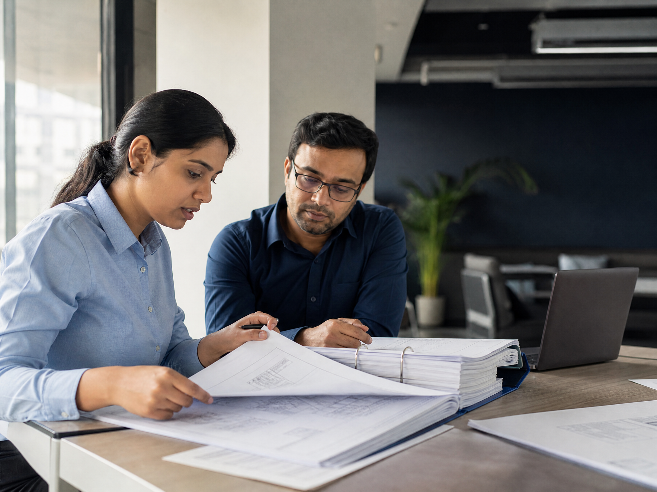 Engineering and document-control professionals reviewing technical drawings and project documents